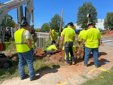 Team of workers engaging in underground bore construction on a sunny day.